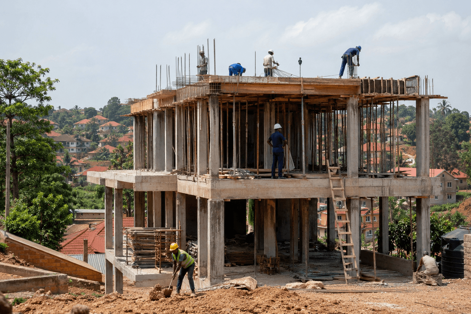 Active residential construction site in Uganda with workers on a multi-storey build